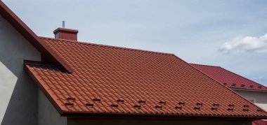 Modern çatı malzemelerinin kullanıldığı evin çatısı.