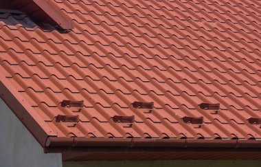 Modern çatı malzemelerinin kullanıldığı evin çatısı.