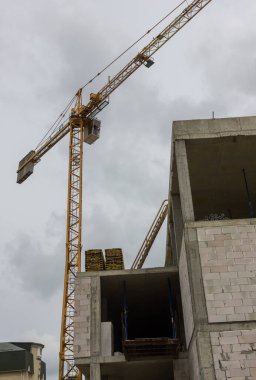 Çok katlı bir ofis inşaatı. İnşaat vinci. Tuğla duvar arkaplan dokusu