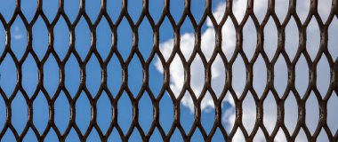 Metal bir kafes içinde gökyüzünün dokusu