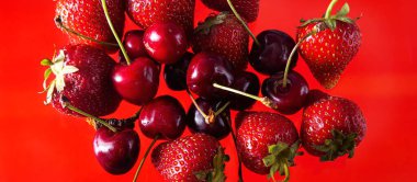 Sağlam bir arka planda olgun çilek ve kiraz, sağlıklı vejetaryen yiyecekler. Güzel