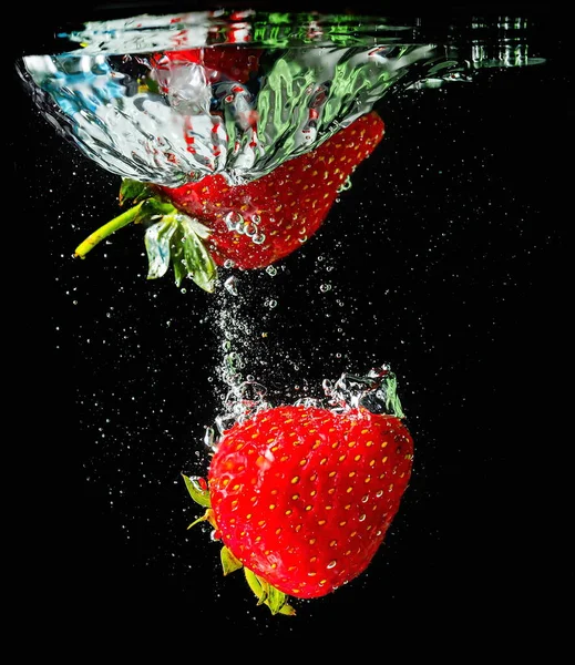 成熟的草莓掉进水里 扬起水花和气泡 — 图库照片