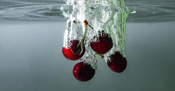 Cerejas Maduras Caem Água Levantando Salpicos Bolhas — Fotografia de Stock