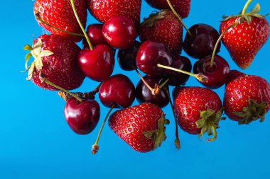 Sağlam bir arka planda olgun çilek ve kiraz, sağlıklı vejetaryen yiyecekler. Güzel