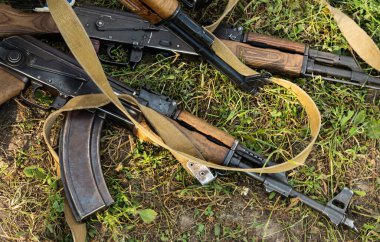 Askeri makineli tüfek tarladaki kuru çimlerin üzerinde yatıyor.