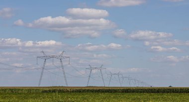 Yukarıdaki güç hattı, güç iletim hattı, yüksek voltajlı elektrik hattı desteği, bulutlu gökyüzünün arka planına karşı..