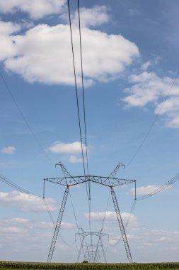 Yukarıdaki güç hattı, güç iletim hattı, yüksek voltajlı elektrik hattı desteği, bulutlu gökyüzünün arka planına karşı..