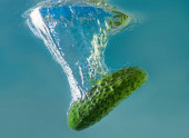 zelená okurka padá do vodního rozptylu hodně sprejů a kapek.