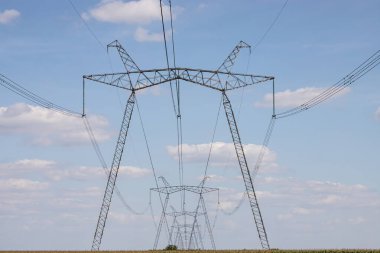 Yukarıdaki güç hattı, güç iletim hattı, yüksek voltajlı elektrik hattı desteği, bulutlu gökyüzünün arka planına karşı..