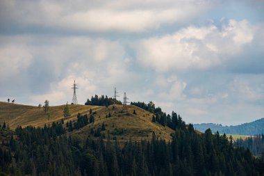 Ukrayna Karpatları 'nın dağ yamaçlarında. Dağın tepeleri ve ormanlar mavi gökyüzünün arka planında.