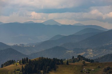 Ukrayna Karpatları 'nın dağ yamaçlarında. Dağın tepeleri ve ormanlar mavi gökyüzünün arka planında.