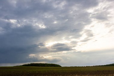 Karanlık bulutlar, gün ışığı kaybolurken geniş ve açık bir alanda toplanır. Karamsar ve büyüleyici bir atmosfer yaratır. Doğanın yansıması ve takdir edilmesi için idealdir..