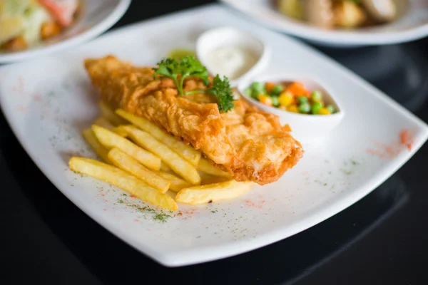 Pescado y patatas fritas servidas con salsa tártara —  Fotos de Stock