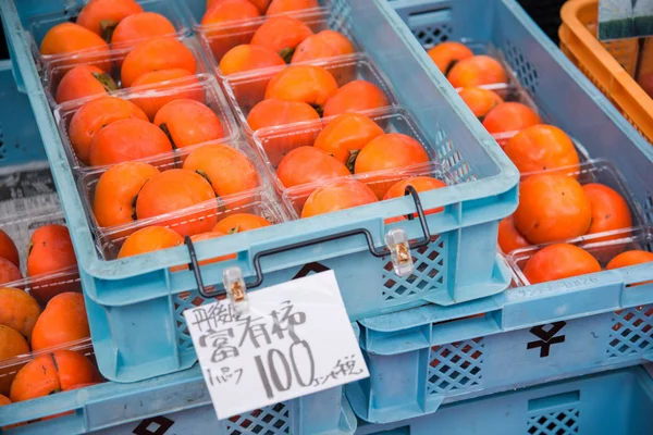 Box of fresh persimmon on sale — Stock Photo, Image