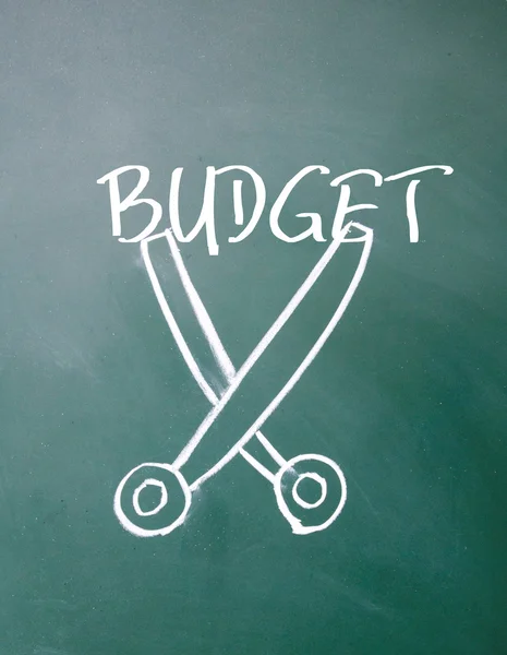 Abstract scissors cut budget symbol on blackboard — Stock Photo, Image