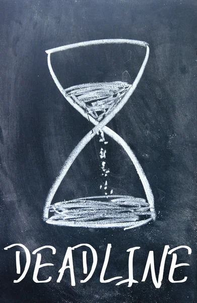 Deadline word and hourglass sign on blackboard — Stock Photo, Image