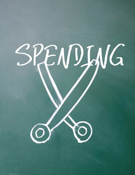 Abstract scissors cut spending symbol on blackboard — Stock Photo, Image