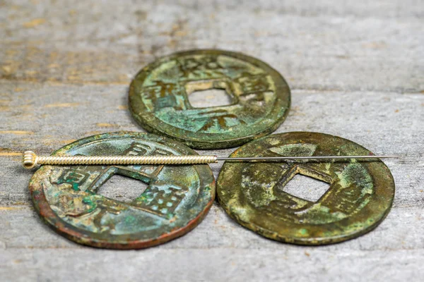 Игла для иглы на антикварной китайской монете — стоковое фото
