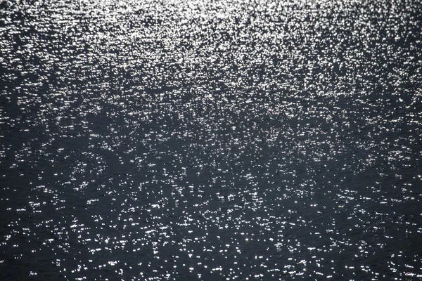 Reflexão da água durante o nascer do sol sobre o mar — Fotografia de Stock