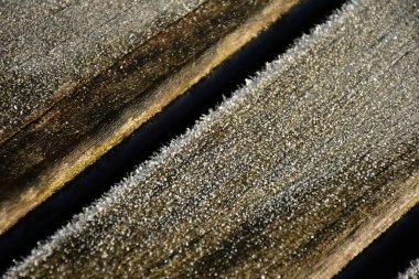 Kışın ahşap bir bankta buzlar eriyor.