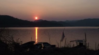 Gölde günbatımı manzarası. Gölün üzerinde güneş ışığının yansıması. 4k