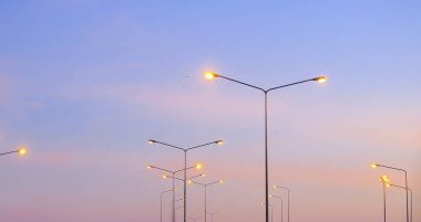 Sokak ışıkları ve günbatımı gökyüzü. Gün batımında güzel bir yolculuk.