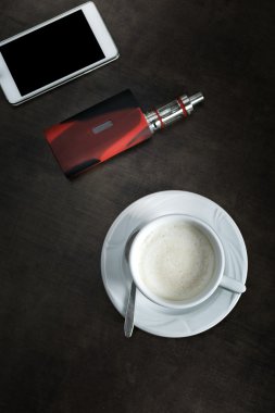 kahve fincanı ve ahşap masa arka plan üstünde smartphone