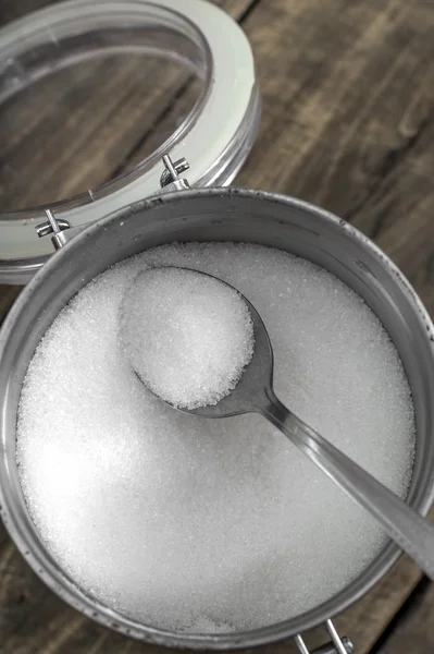 Cuillères de sucre blanc cristallin sur fond de sucre — Photo