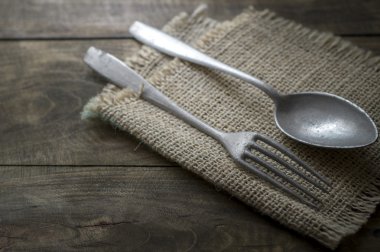 Tahta masadaki eski çatal bıçak takımı.