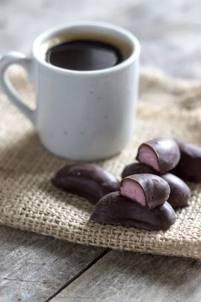 Caramelle al cioccolato e una tazza di caffè — Foto Stock