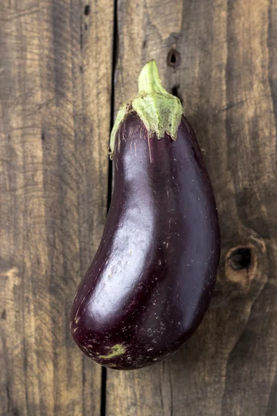 Rå aubergine eller äggplantor på trä bakrund. — Stockfoto