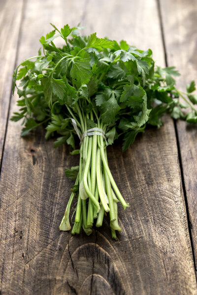 tied fresh parsley on wooden surface