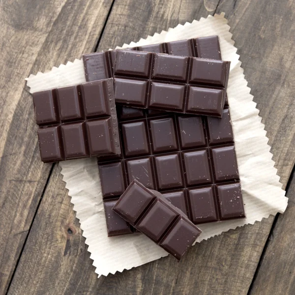 Trasiga chokladkaka på träbord. — Stockfoto