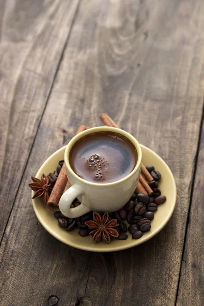 Tasse Kaffee mit Zimtstangen auf Holz — Stockfoto