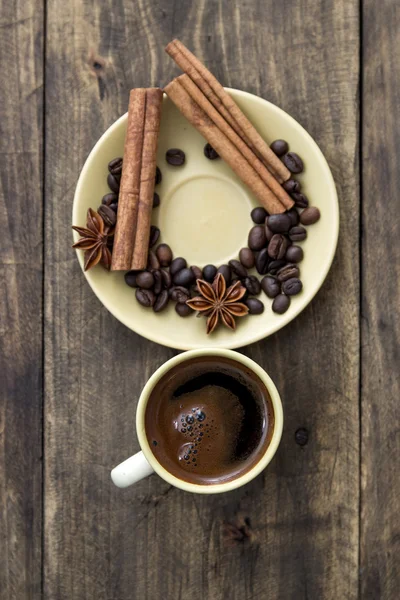 Cup of coffee with cinnamon sticks on wood — Stock Photo, Image