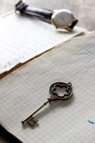 Oud boek en een messing toets op een vintage oppervlak — Stockfoto