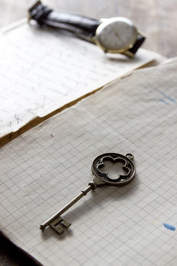 old book and a brass key on a vintage surface