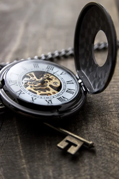 Zegarek kieszonkowy na drewnianym stole grunge — Zdjęcie stockowe
