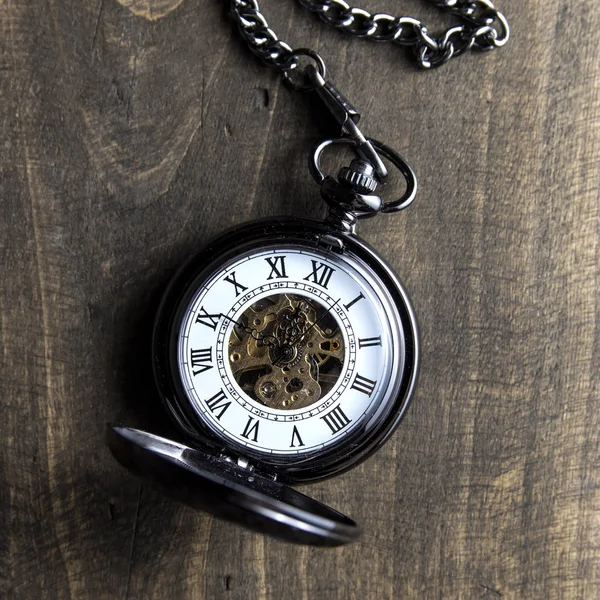 Reloj de bolsillo en mesa de madera grunge — Foto de Stock