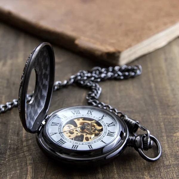 Pocket watch over grunge wooden table — Stock Photo, Image