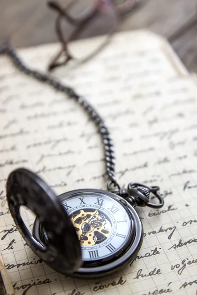 Vintage pocket watch on old book — Stock Photo, Image