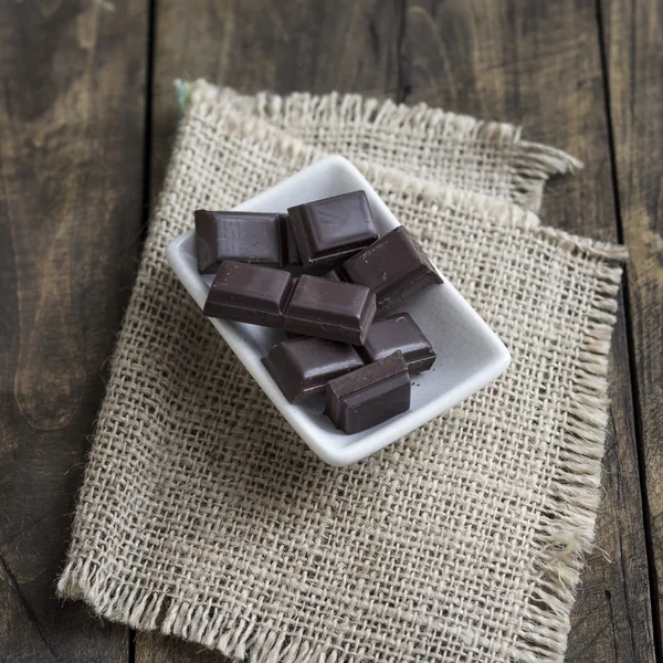 Gebroken chocolade bar op houten tafel — Stockfoto