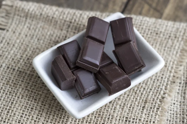 Barra de chocolate quebrada na mesa de madeira — Fotografia de Stock