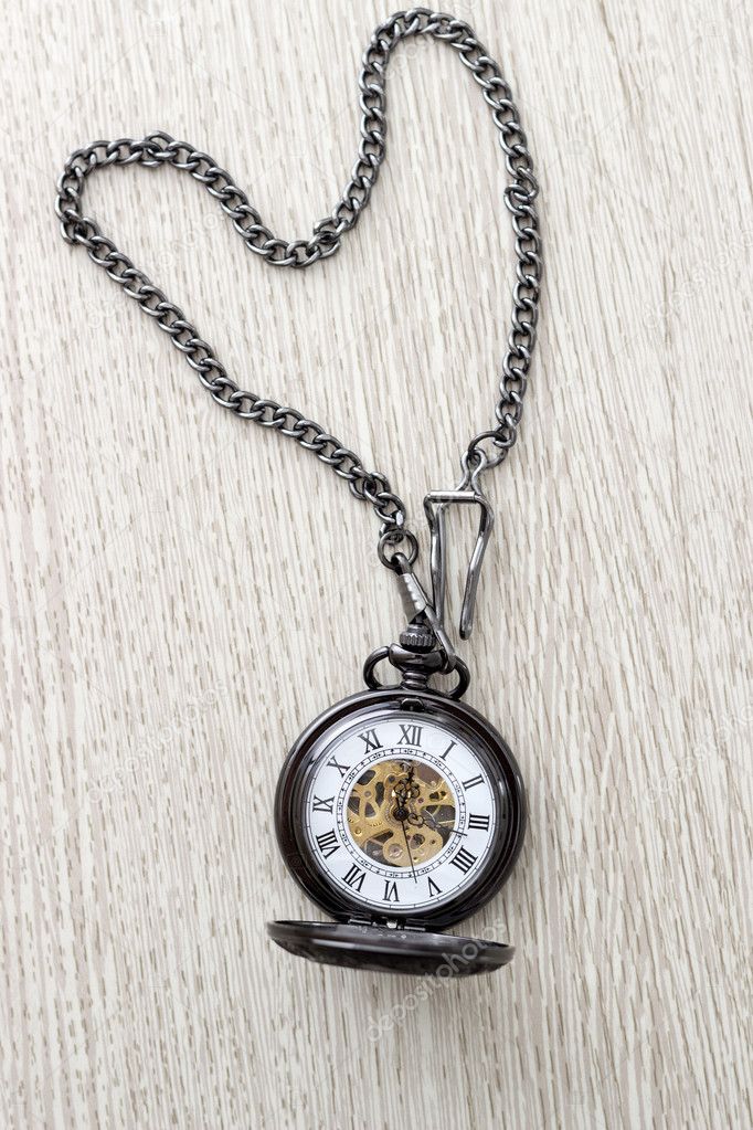 pocket watch on  wooden table