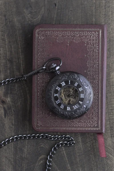 Карманные часы на старой книге — стоковое фото