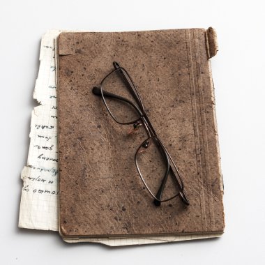 glasses and old notebook on table clipart