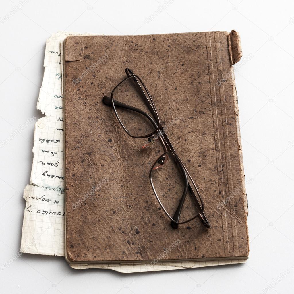 glasses and old notebook on table