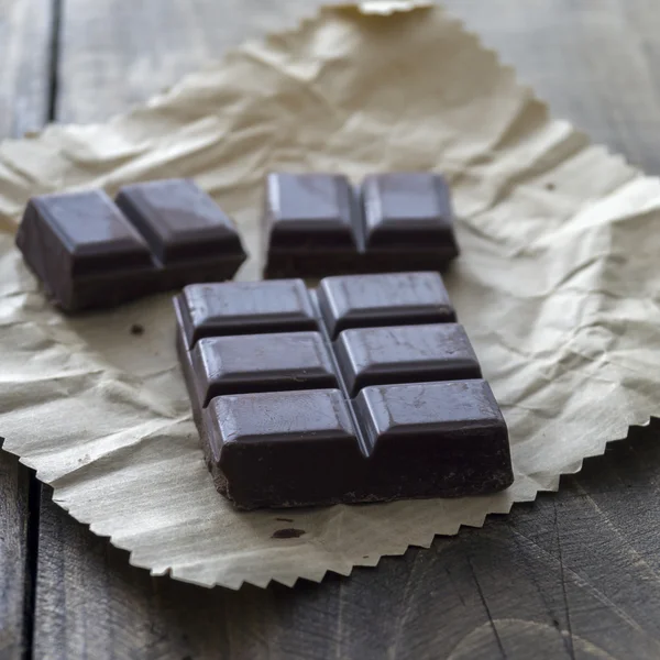 Noble dark chocolate on a wooden table — Stock Photo, Image