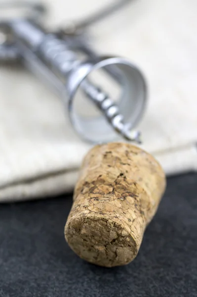 Cortiça de vinho e saca-rolhas na mesa — Fotografia de Stock