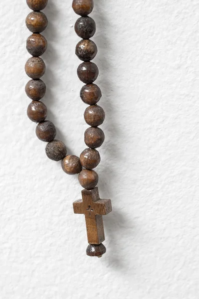 Rosary beads  hanging against white wall — Stock Photo, Image